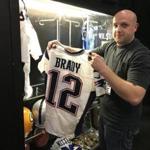 Jeremy Kraft of Hunt Auctions held up a Tom Brady jersey that could fetch $50,000 at auction.